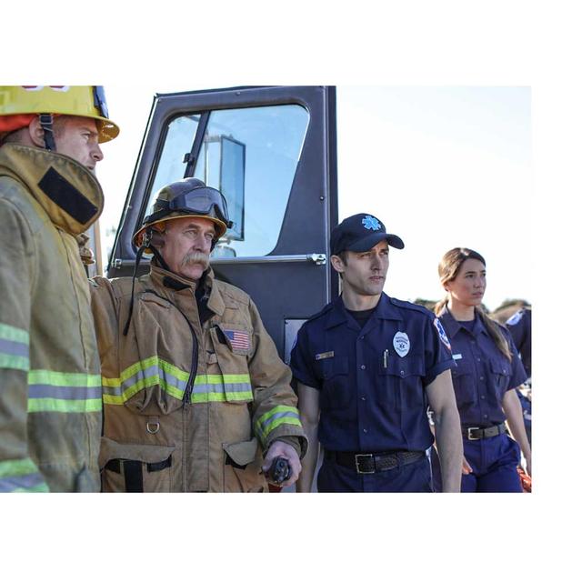 Firefighters and first responders stand together on the site of an emergency call.
